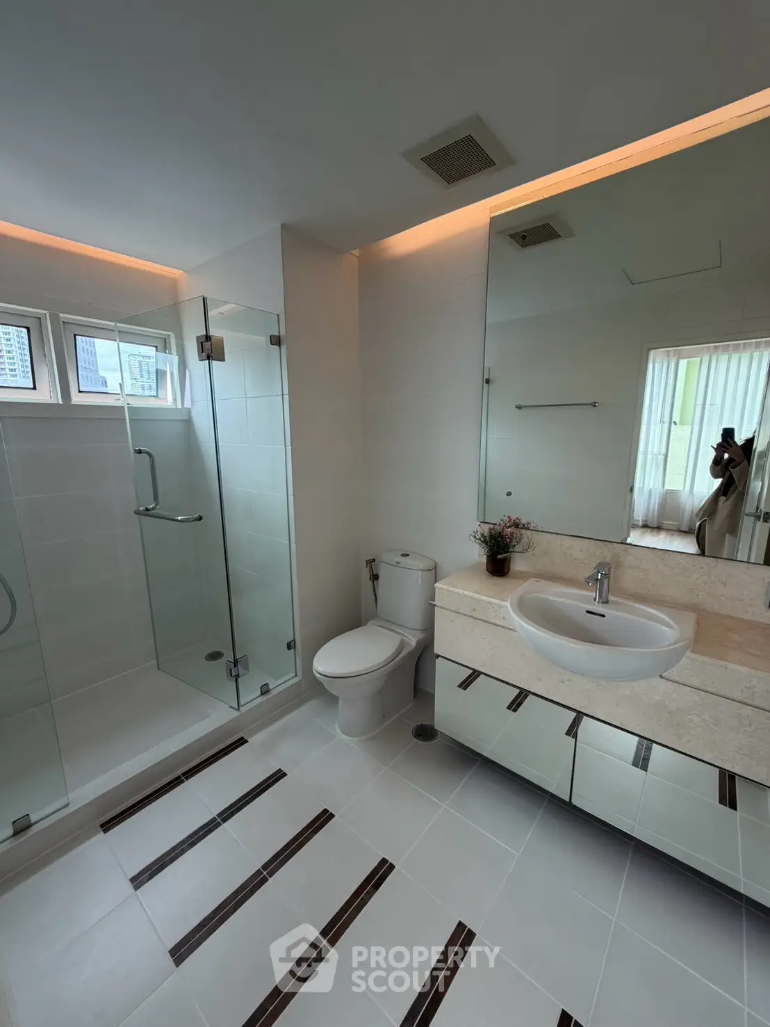 Modern bathroom with glass shower and sleek vanity in a contemporary apartment.