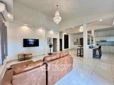 Spacious open-plan living room with modern kitchen and elegant chandeliers