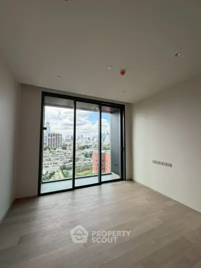Spacious room with floor-to-ceiling windows offering stunning city views, perfect for modern living.