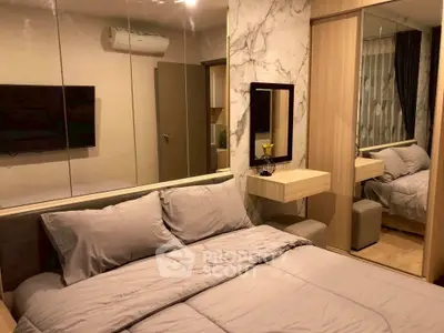 Cozy bedroom with modern decor, mirrored wall, and stylish bedding in a chic apartment.