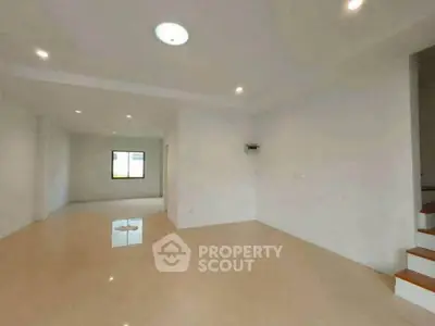 Spacious empty living room with polished floors and bright lighting