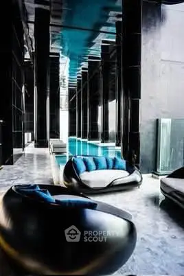 Luxurious indoor pool area with modern seating and sleek black design.