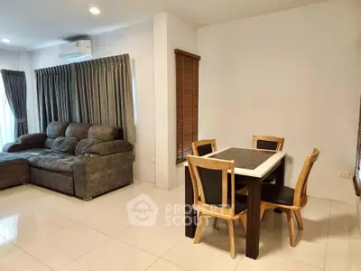 Spacious living room with modern furniture and dining area in a cozy apartment.