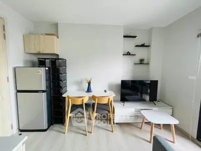 Modern living room with sleek furniture and compact design, featuring a TV and dining area.