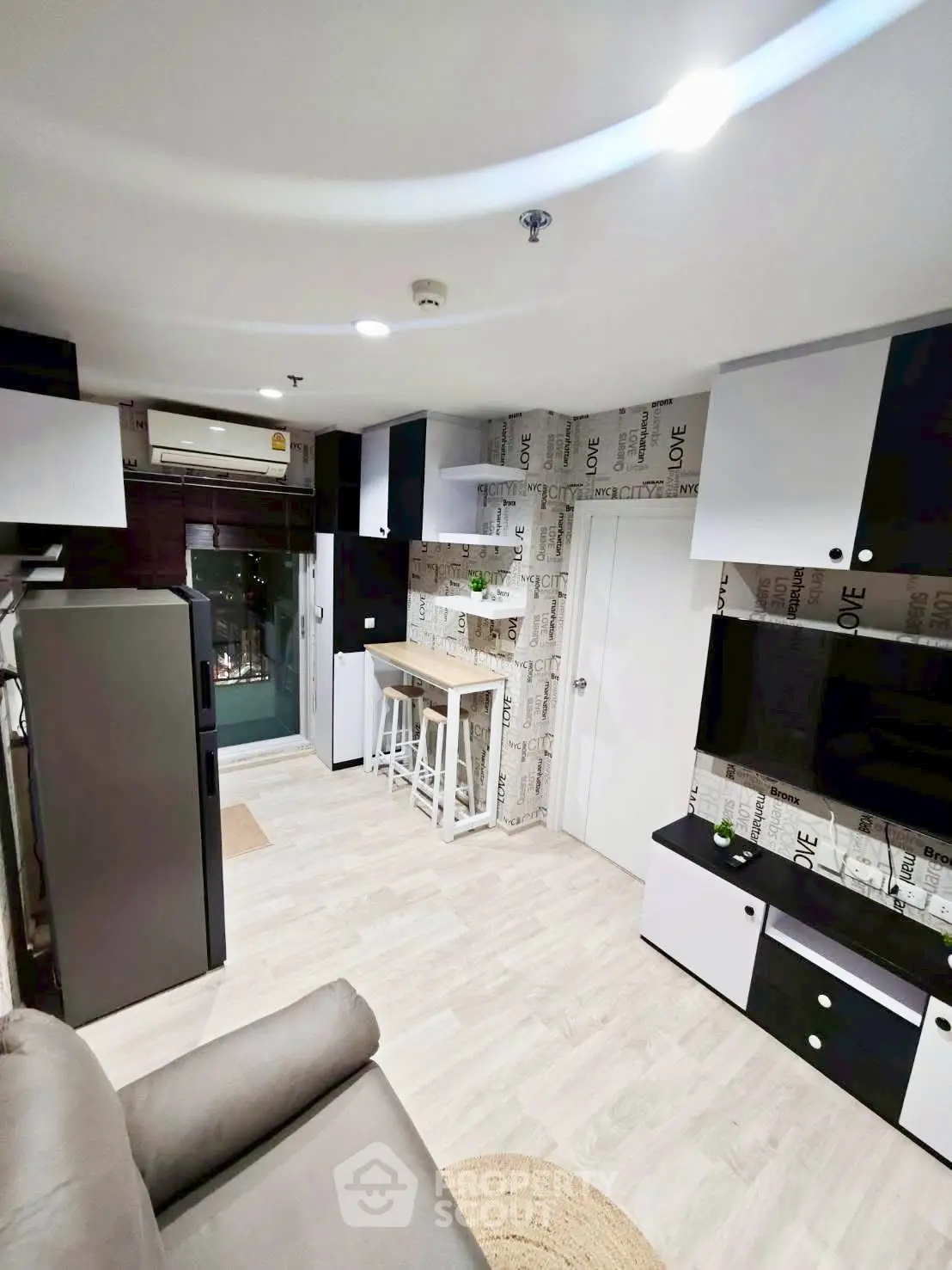 Modern living room with stylish decor and open layout, featuring sleek cabinetry and cozy seating area.