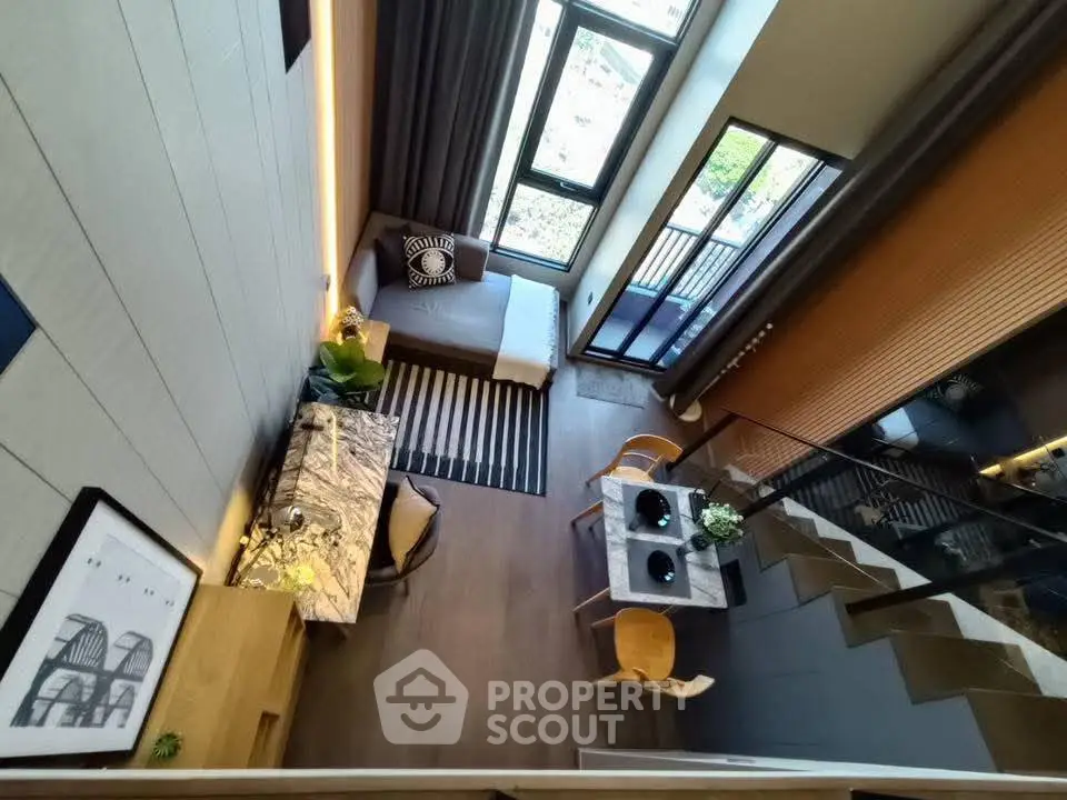 Modern loft apartment with high ceilings, stylish decor, and large windows offering natural light.
