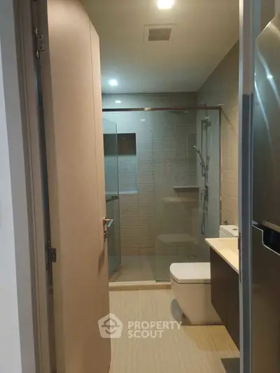 Modern bathroom with glass shower and sleek fixtures in a contemporary apartment.