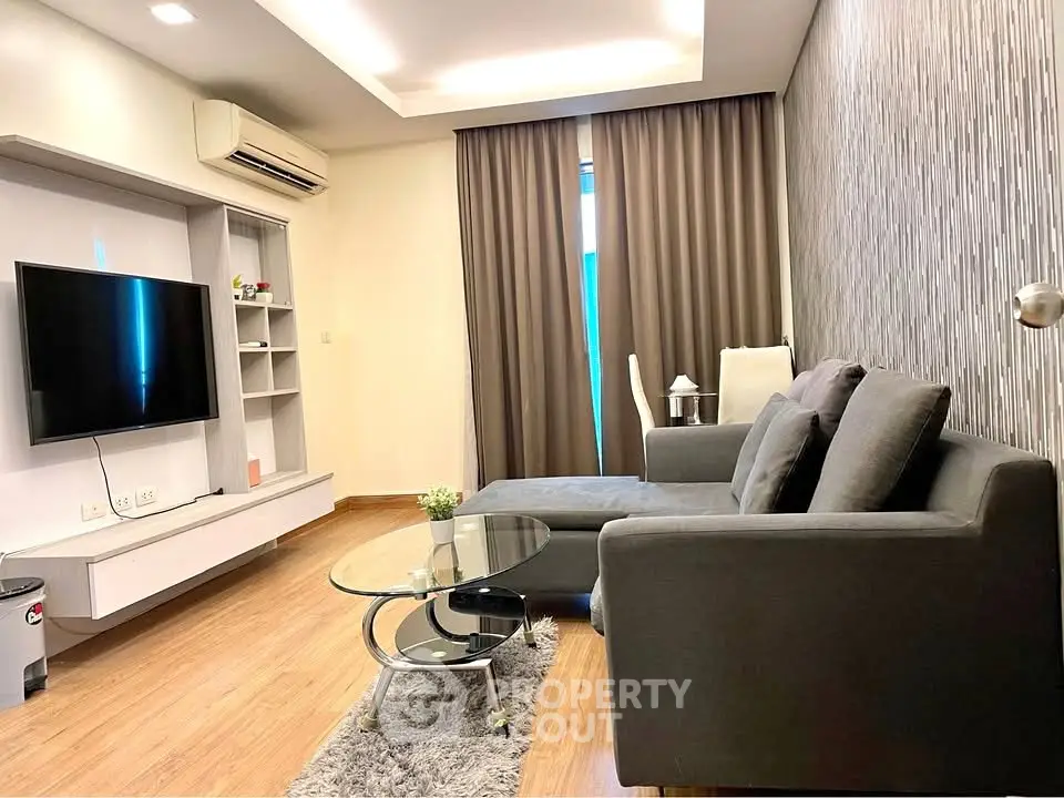 Modern living room with sleek furniture and wall-mounted TV in stylish apartment.