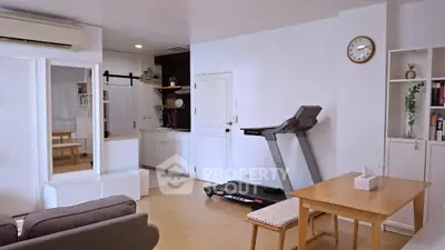 Spacious living room with treadmill and modern decor in a cozy apartment.