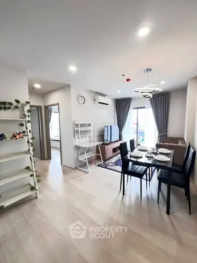 Modern living room with dining area, stylish decor, and natural light in a contemporary apartment.
