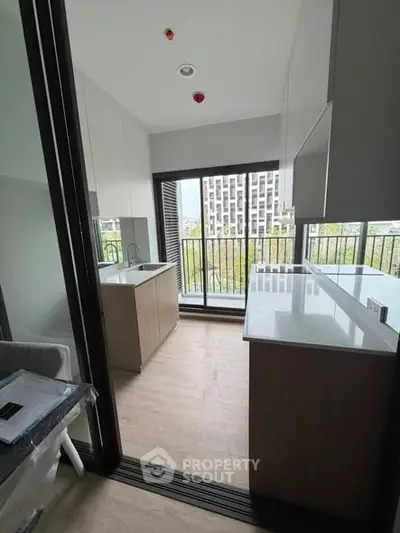 Modern kitchen with open layout and balcony view in urban apartment