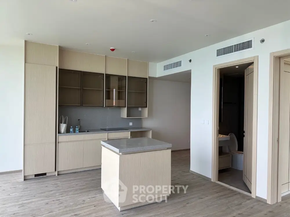 Modern kitchen with island and sleek cabinetry in open layout apartment.