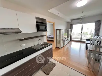 Modern open-plan living room with kitchen and balcony view