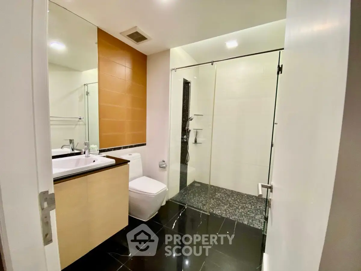 Modern bathroom with sleek design, glass shower, and elegant fixtures.