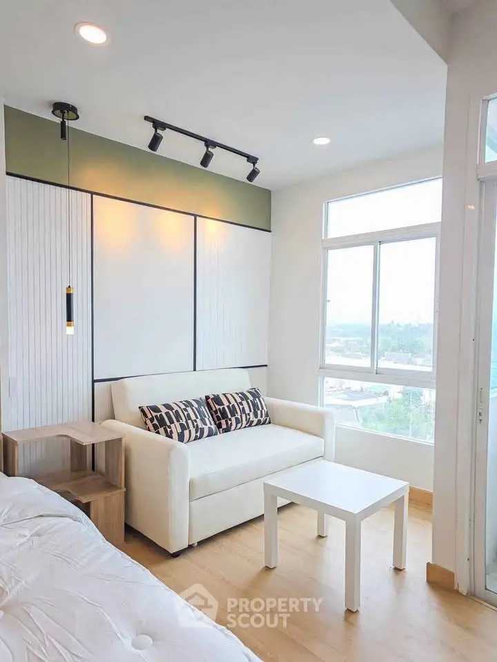 Bright modern living room with cozy white sofa and large window view