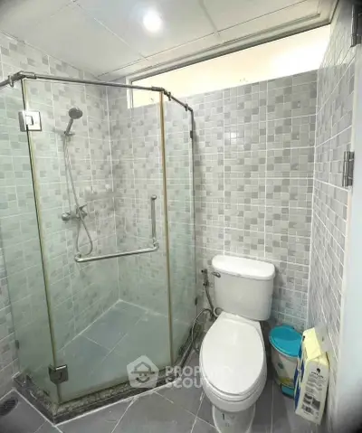 Modern bathroom with glass shower and tiled walls in a contemporary home.