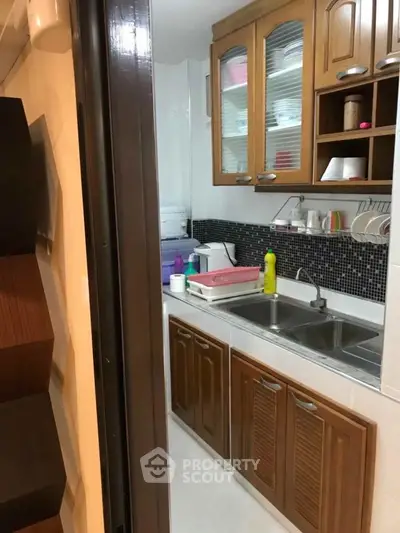 Charming kitchen with wooden cabinets and modern backsplash, perfect for culinary enthusiasts.