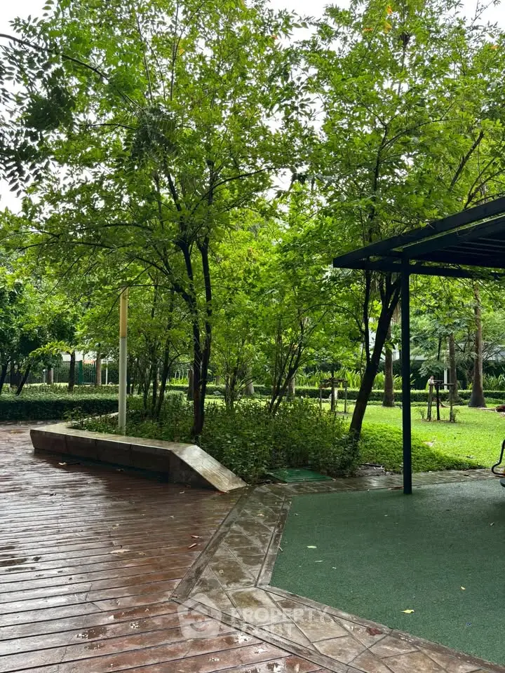Lush green garden with wooden deck and seating area in a serene residential community.