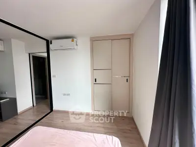 Modern bedroom with mirrored wardrobe and air conditioning in a stylish apartment.