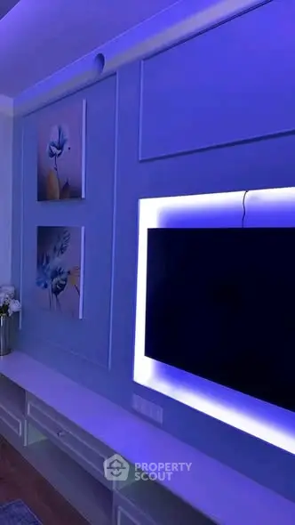Modern living room with ambient lighting and wall-mounted TV