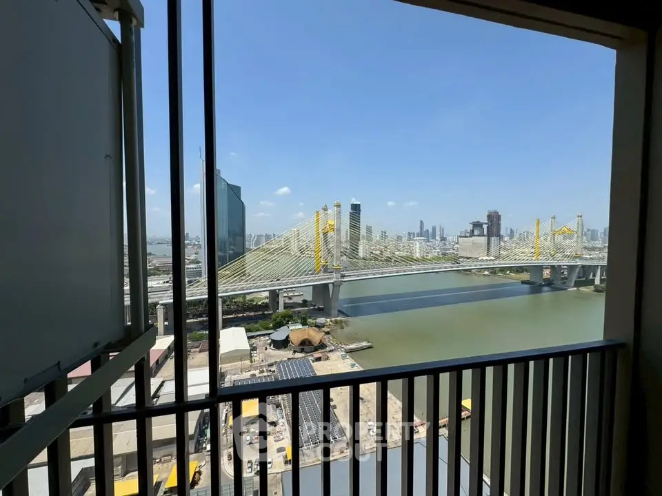 Stunning cityscape view from a high-rise balcony overlooking a river and iconic bridge.