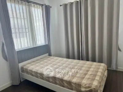 Cozy bedroom with natural light and stylish curtains, perfect for relaxation.