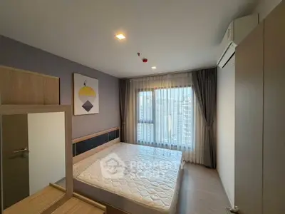 Modern bedroom with large window and city view, featuring stylish decor and air conditioning.