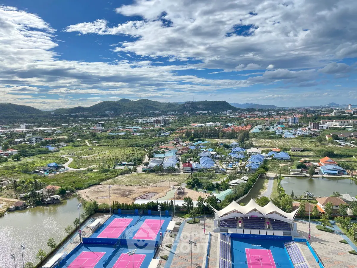 Stunning aerial view of tennis courts with scenic mountain backdrop, perfect for sports enthusiasts.