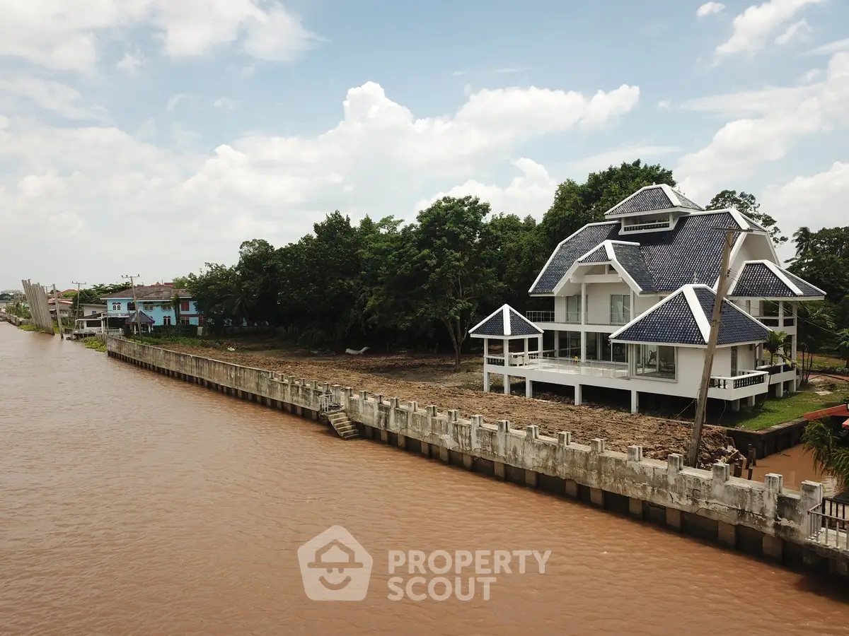 Stunning riverside property with modern architecture and lush greenery, offering serene water views and luxurious living.