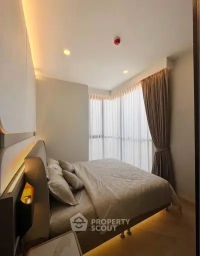 Modern bedroom with elegant lighting and large windows offering natural light.