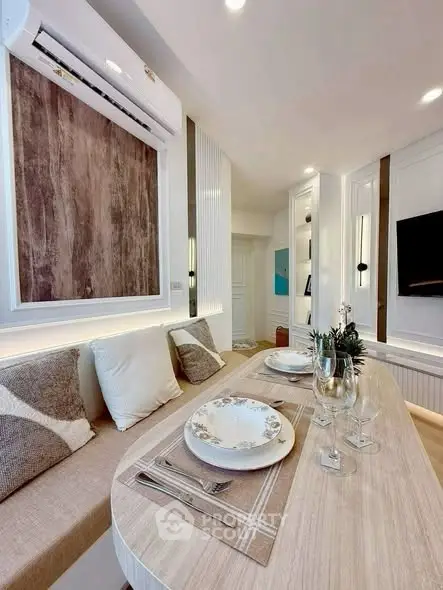 Modern dining area with elegant table setting and cozy seating in a stylish apartment.