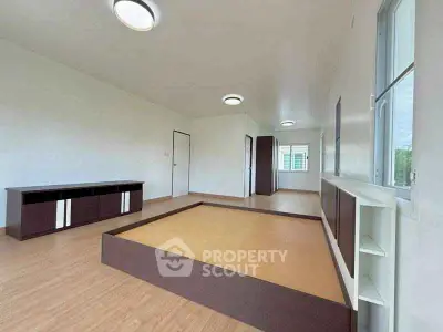 Spacious modern living room with elevated platform and sleek cabinetry.