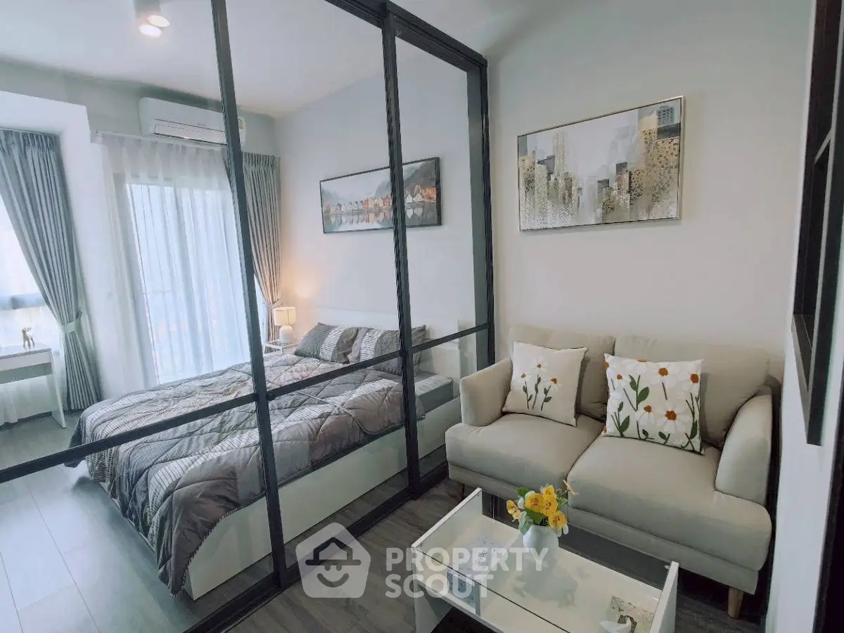 Modern studio apartment with glass partition, cozy living area, and stylish bedroom.