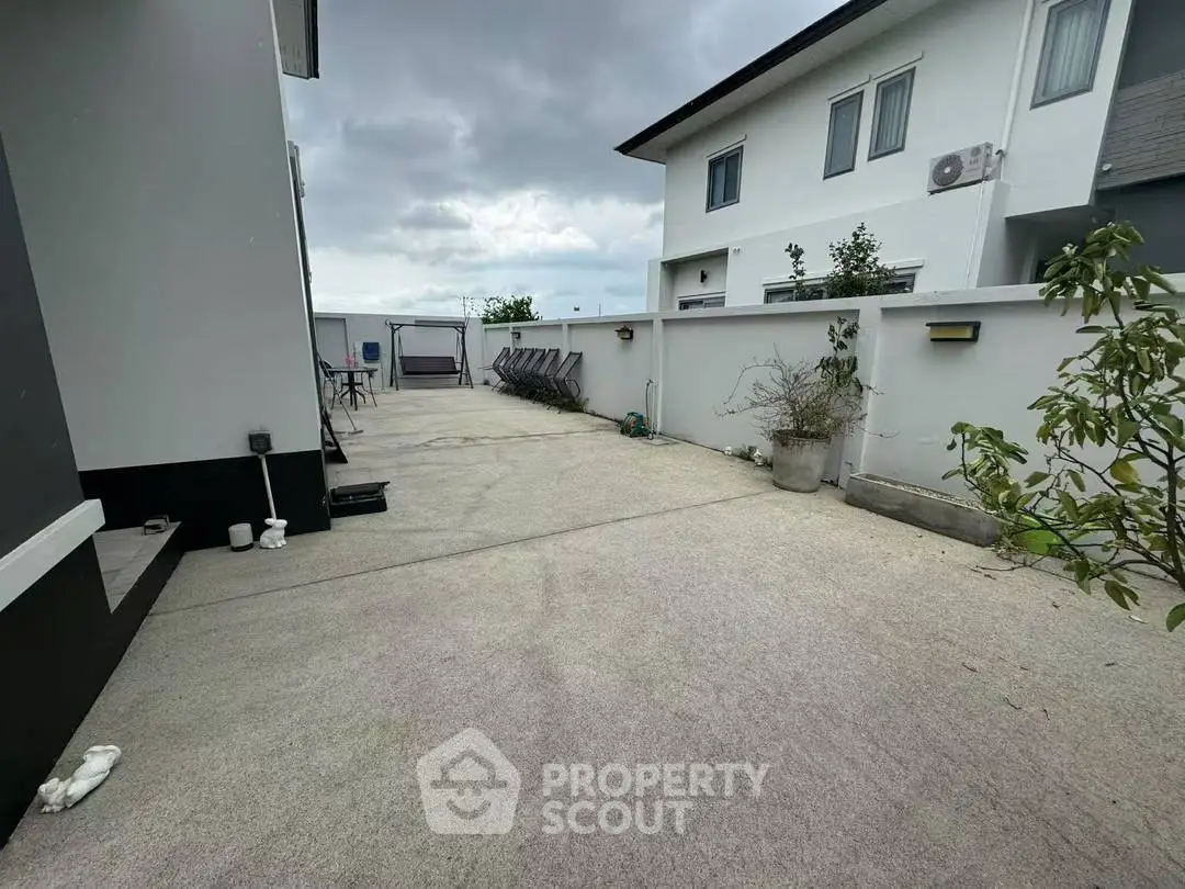 Spacious outdoor area with modern building and cloudy sky, perfect for relaxation and gatherings.