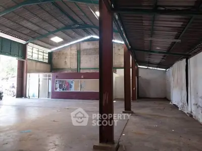 Spacious industrial warehouse with high ceilings and ample natural light.