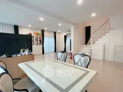 Spacious modern living area with elegant dining setup and staircase