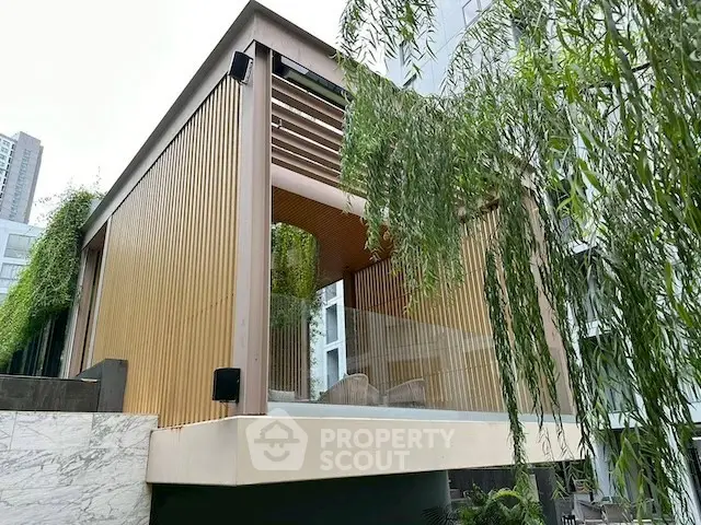 Modern architectural exterior with sleek wooden paneling and lush greenery.