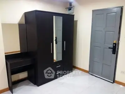 Modern bedroom with sleek wardrobe and secure door, perfect for stylish urban living.