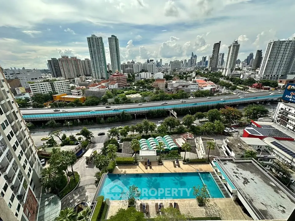 Stunning cityscape view from high-rise apartment with pool and lush greenery