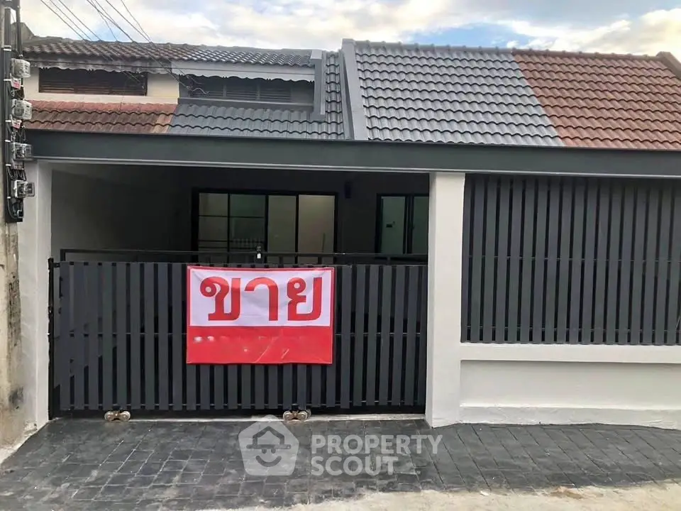 Charming single-story home with modern facade and gated entrance for sale.