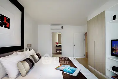Modern bedroom with stylish decor and ensuite bathroom in a contemporary apartment.