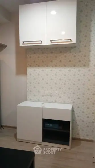 Modern kitchen with sleek white cabinets and floral wallpaper accent