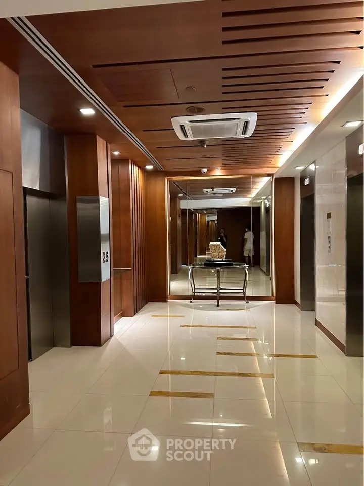 Luxurious building elevator lobby with modern wood paneling and sleek lighting.