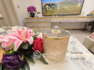 Elegant living room with decorative trash can and vibrant floral arrangement