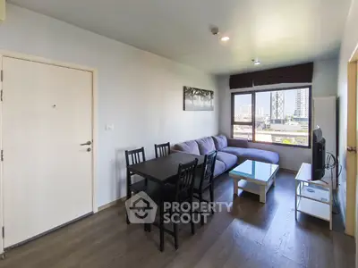 Modern living room with city view, featuring sleek furniture and natural light.
