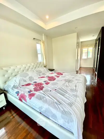 Spacious bedroom with elegant decor and hardwood flooring