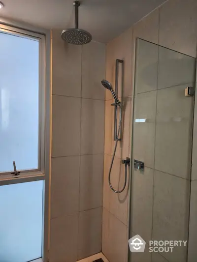 Modern bathroom with sleek shower design and large window for natural light.