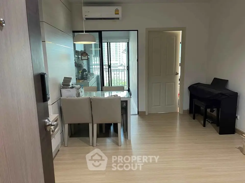Modern dining area with sleek furniture and balcony view in a stylish apartment.