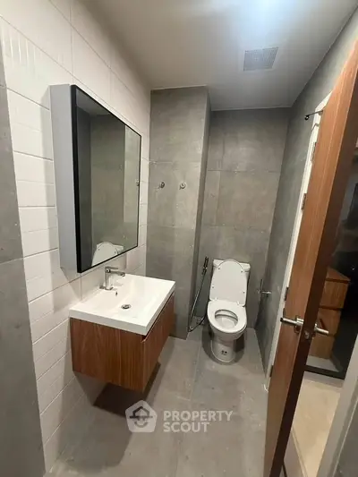 Modern bathroom with sleek design, featuring a wall-mounted sink and contemporary fixtures.