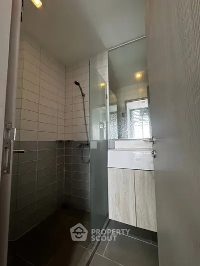 Modern bathroom with sleek shower and stylish vanity in contemporary apartment.